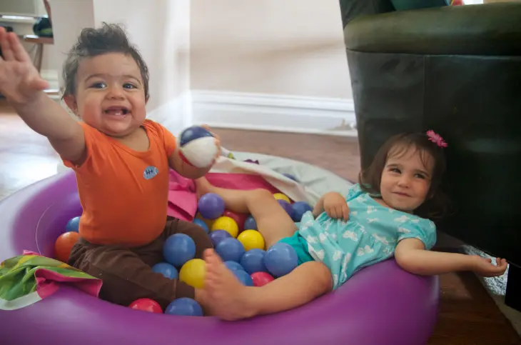 Two kids playing in a sensory ball pit.