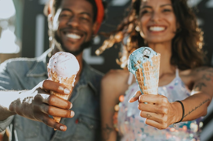 a men and a woman holding ice creams