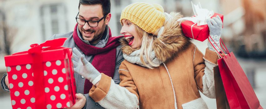 happy couple holding christmas gifts
