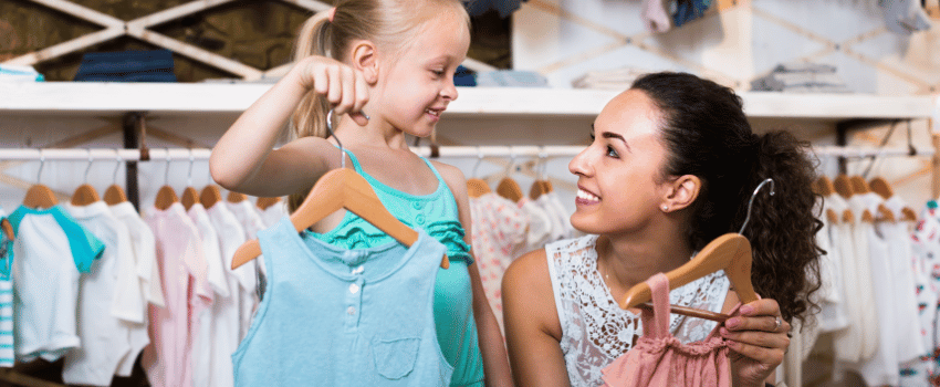 smiling mother and daughter shopping for clothes